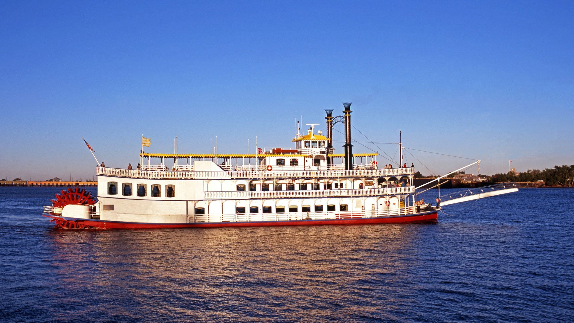 Red-trimmed paddlewheel riverboat on open water