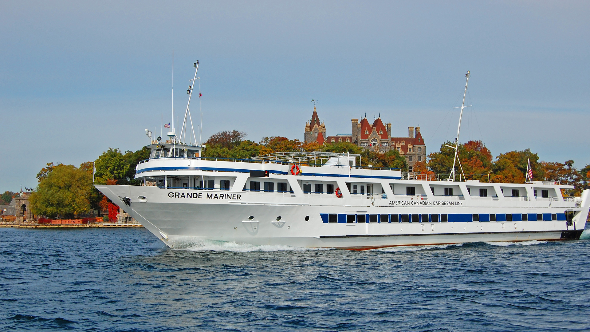 Small cruise ship Grande Mariner passing a castle in the Thousand Islands